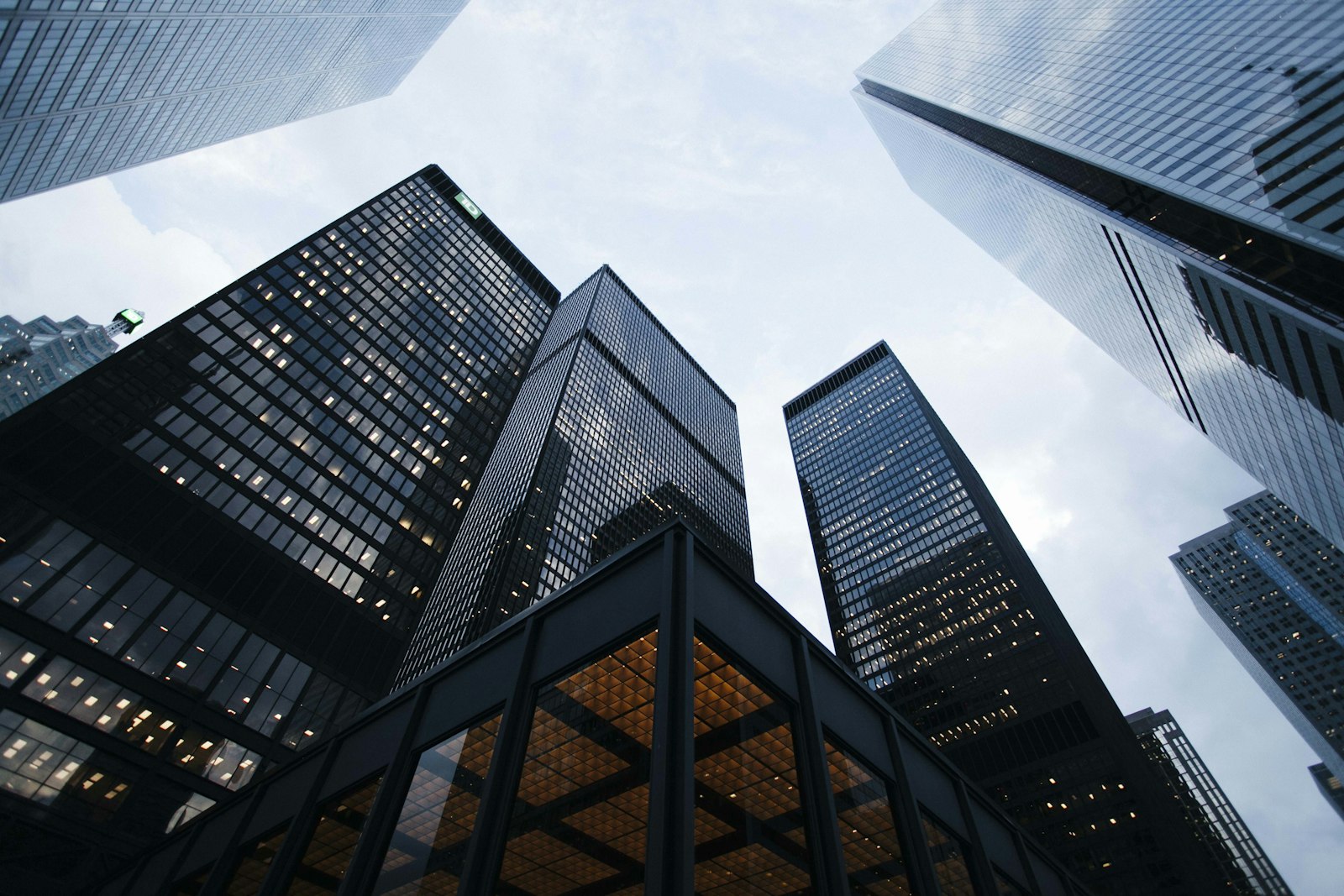 Tall glass office towers of a financial district photographed from ground level looking upward